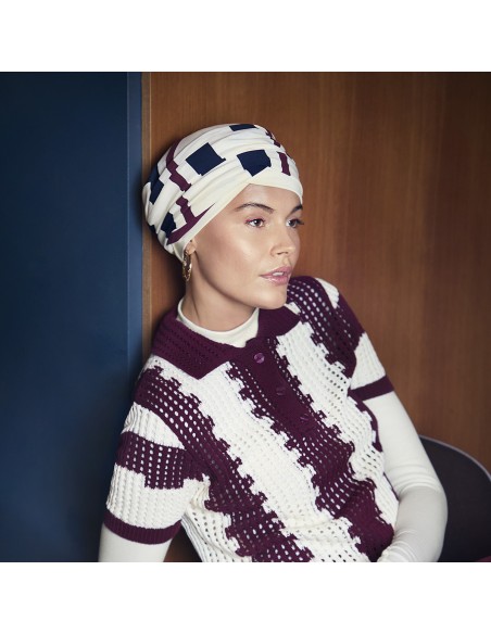 Turbante oncológico Elma Viva con estampado geométrico en tonos burdeos.
