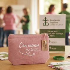 Neceser rosa solidario de la AECC con lema Con Rasmia de frente sobre fondo neutro 2